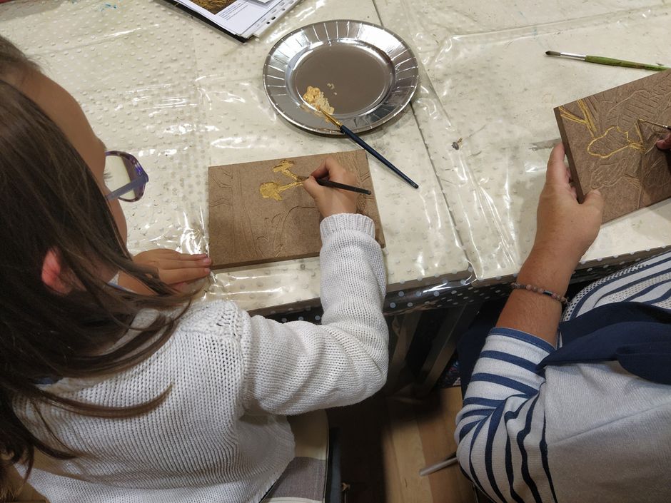 Atelier "Bois gravé" mené par Béatrice Giffo - application de peinture dorée dans les creux (Voir légende ci-après)